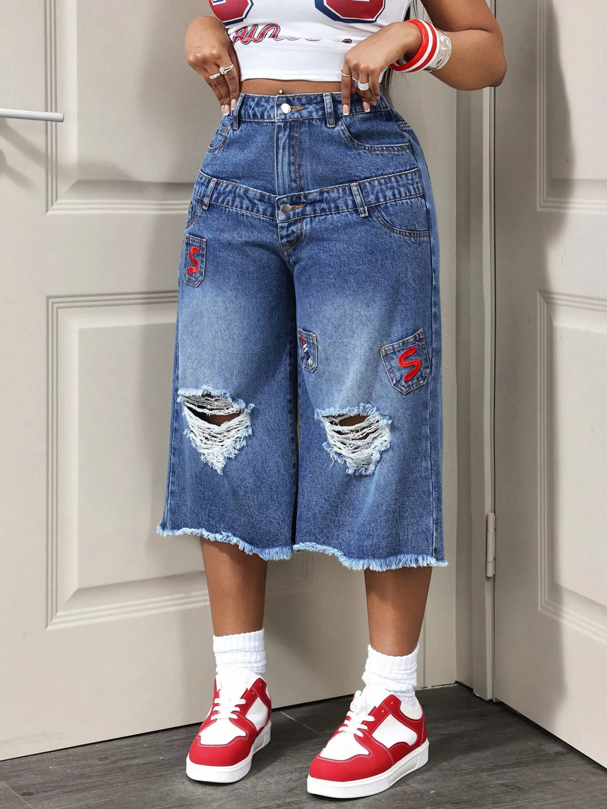 Distressed wide-leg denim capris in blue.